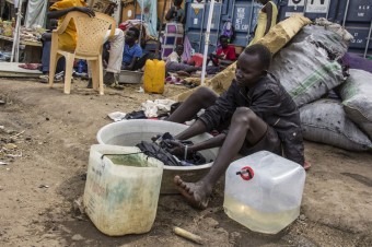 Joven deslocado africano lavando roupa | IKMR