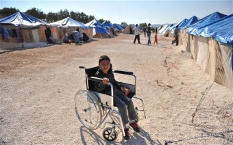 Um menino sírio em uma cadeira de rodas em QAH campo de refugiados.