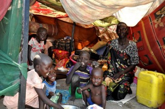 Uma família sentada dentro de um abrigo improvisado na base da ONU em Malakal, no Sudão do Sul. Foto: OCHA