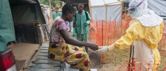 Aperto de mão. Contato físico só é permitido mediante o uso do traje especial de proteção. - Sylvain Cherkaoui/MSF 