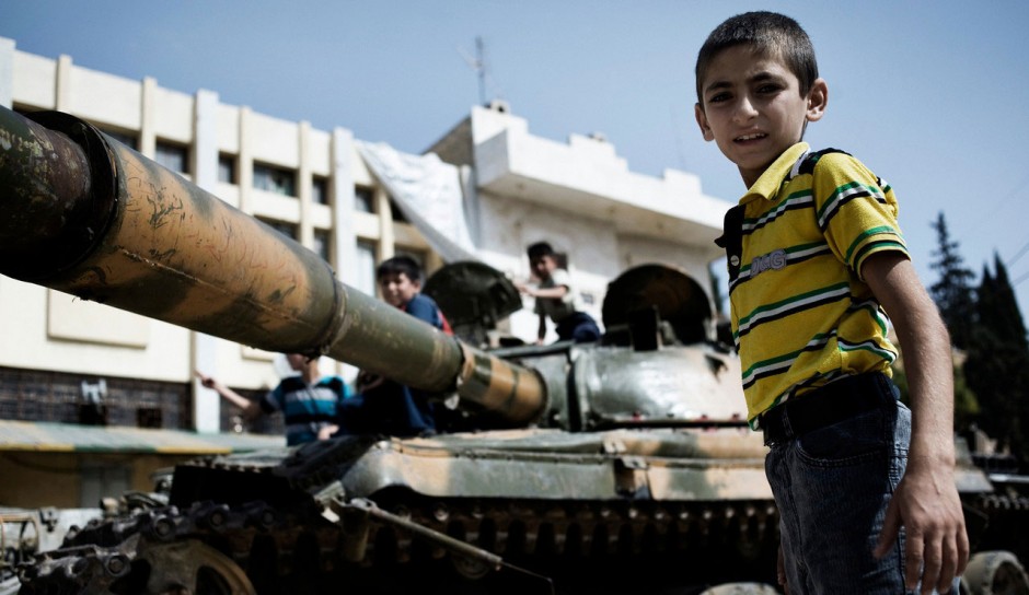 Crianças brincam com um tanque destruído do exército sírio em Aleppo. Foto: UNICEF/Romenzi