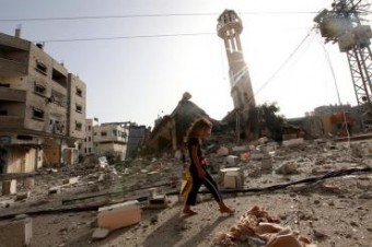 Garota palestina anda em meio a destroços de uma mesquista no campo de refugiados de Al Nusairat, no Foto: Agência Efe