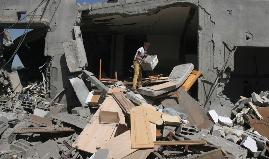 Um menino palestino procura por pertences depois que sua casa foi destruída pelo governo de Israel em um ataque aéreo em Khan Yunis, Gaza. Foto: UNICEF/Eyad El Baba