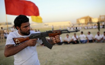 Voluntário xiita do Conselho Supremo Islâmico Iraquiano aponta arma durante treinamento em Najaf