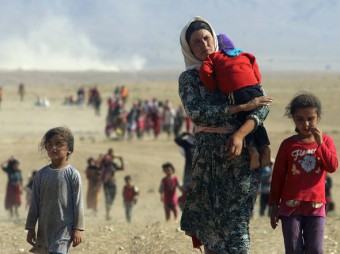 Membros da minoria yazidi fugindo da violência das forças leais ao Estado Islâmico